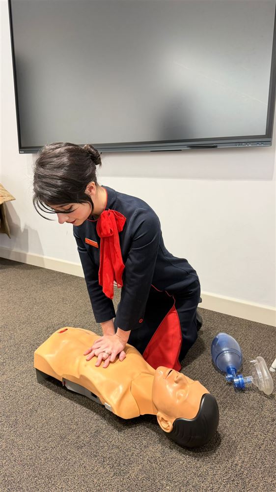 Tripulante practicando compresiones de RCP en un maniquí de prácticas