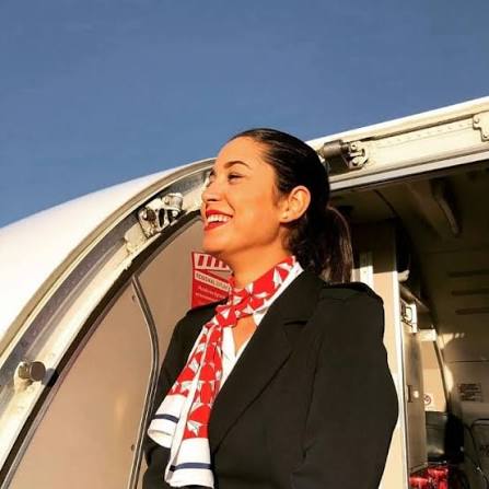 Tripulante de Air Hostess Vigo sonriendo en la puerta de un avión